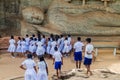 POLONNARUWA, SRI LANKA - JULY 22, 2016: Children in school uniforms visit reclining Buddha statue at Gal Vihara rock Royalty Free Stock Photo