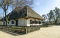 Old traditional village house in the background of the garden. Clay white walls and plank roof