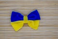 Poltava, Ukraine - 27 November, 2022: A bow made of blue-yellow fabric as the flag of Ukraine on a bamboo background