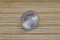 Poltava, Ukraine - 27 November, 2022: One halogen lamp for ceiling lamps on a bamboo background Royalty Free Stock Photo