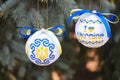 Poltava, Ukraine - 30 October, 2023: Two New Year\'s balls in yellow and blue colors hang on the Christmas tree Royalty Free Stock Photo