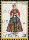 Vintage stamp printed in Greece 1974 shows woman in folk costume