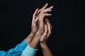 Male and female hands on dark background. Polyamory concept