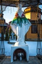 Old rustic wooden orthodox christian church and the statue of the Virgin Mary Royalty Free Stock Photo