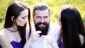 Polygamy love. Relationships concept. Love triangle. Brutal bearded man with girls.