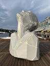 A polygonic face sculpture looking into the sky, located on the waterfront of Woolloomooloo Wharf