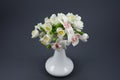 Polymer clay flower bouquet in a white vase on a gray background