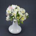 Polymer clay flower bouquet in a white vase on a gray background