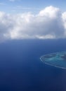 Polynesia. The atoll in ocean through clouds. Aerial view Royalty Free Stock Photo
