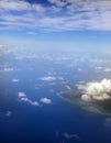 Polynesia. The atoll in ocean through clouds. Aerial view Royalty Free Stock Photo