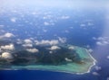 Polynesia. The atoll in ocean through clouds. Aerial view Royalty Free Stock Photo