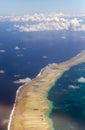 Polynesia. The atoll in ocean through clouds. Aerial view Royalty Free Stock Photo