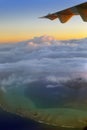 Polynesia. The atoll in ocean through clouds. Aerial view Royalty Free Stock Photo