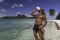 Polynesian man playing shell and ukulele on Bora Bora Island beach and Lagoon - French Polynesia