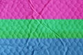 Polysexual pride flag on an uneven textured surface.