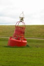 Polyurea sea buoy on the dam. Dike on the Dutch North Sea coast, red and white navigation buoy.