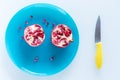 Pomegranate on a blue plate and yellow knife