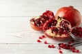 Pomegranate, bowl and spoon on background, close up