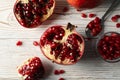 Pomegranate, bowl and spoon on background, top view