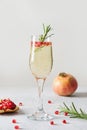 Pomegranate Christmas cocktail with rosemary, sparkling wine on white. Xmas Holiday drink