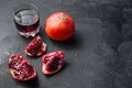 Pomegranate cuts with seeds  in front of garnet cut and juice in glass side view, on black background, space for text Royalty Free Stock Photo