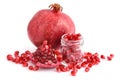 Pomegranate fruit and glass jar with seeds isolated on white background