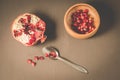 Pomegranate fruit and grains in a wooden bowl and a spoon/Pomegranate fruit and grains in a wooden bowl and a spoon against a dark