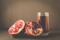 Pomegranate fruit and juice in glass/Pomegranate fruit and juice in glass on dark background, selective focus