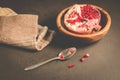 pomegranate fruit in a wooden bowl/ pomegranate fruit in a wooden bowl and seeds on the table and in a spoon