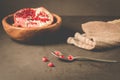 pomegranate fruit in a wooden bowl/pomegranate fruit in a wooden bowl and seeds on the table and in a spoon, selective focus