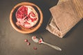 pomegranate fruit in a wooden bowl/pomegranate fruit in a wooden bowl and seeds on the table and in a spoon, top view