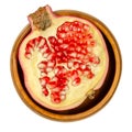 Pomegranate half, split open fruit with red seeds in a wooden bowl