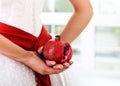 Pomegranate in hands of a bride