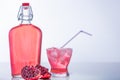 Pomegranate with Juice Bottle and full glass with ice and Straw