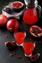 Pomegranate juice in glass and pitcher on the black background Royalty Free Stock Photo