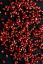Pomegranate seeds on black background, top view