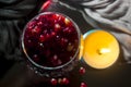 Pomegranate bones in a glass with candles in a dark manner.