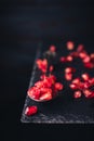 pomegranate seeds on an old vintage spoon isolated on stone table. copy space for text. vintage style Royalty Free Stock Photo