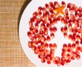 Pomegranate seeds on plate in the shape of a Christmas tree with carrot star on the table. Dessert idea for kids. New Royalty Free Stock Photo