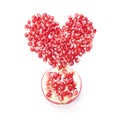 Pomegranate seeds in shape of heart and half of fruit