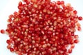 Heap of red pomegranate seeds on a white background