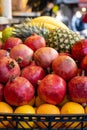 Pomegranate and tropical fruits, bananas, pineapples, lemons, citrus fruits on display at market. Royalty Free Stock Photo