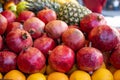 Pomegranate and tropical fruits, bananas, pineapples, lemons, citrus fruits on display at market. Royalty Free Stock Photo