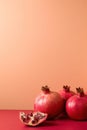 Ripe red pomegranates on a coral background