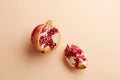 Pomegranates on a grey tray on pastel pink background