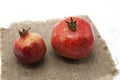 Pomegranates have broken into pieces with red berries on a porcelain plate on a white background.