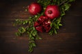 pomegranates with leaves, on a wooden table, rustic style Royalty Free Stock Photo