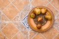 Pomegranates on pattered wooden plate. Tiles