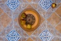 Pomegranates on pattered wooden plate. Tiles