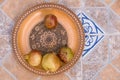Pomegranates on pattered wooden plate. Tiles